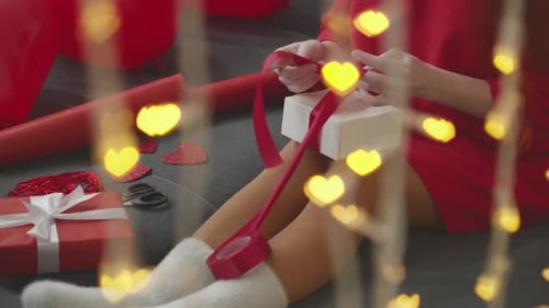 Woman Wrapping Birthday Presents with Festive Lights