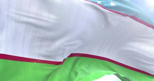Realistic Waving Flag of Uzbekistan against Blue Sky