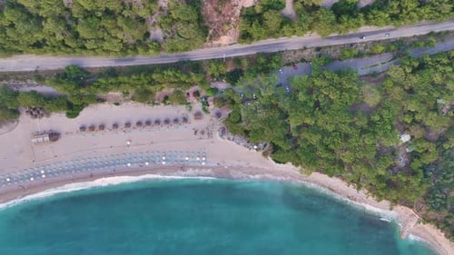 Calm Turquoise Waves Gently Caress the Sandy Shore Adorned with Rows of Beach Umbrellas and Sunbeds