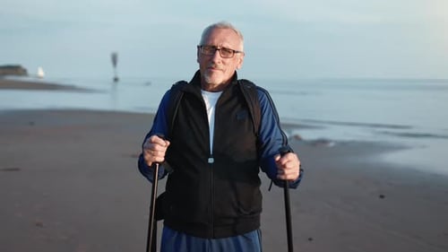 Healthy Sports 70s Grandfather Backpacker Posing Walking Stick Outdoor Activity at Sunset Sand Beach