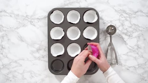 Flat Lay Baking Chocolate Cupcakes Lining Metal Cupcake Pan with Foil Cupcake Liners