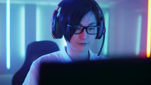 Enthusiastic Young Man Gaming at Home in Blue Light