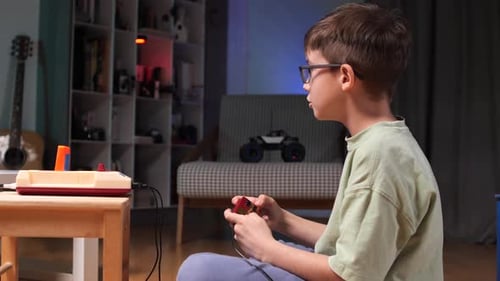 Boy Plays Retro Wired Video Game at Home