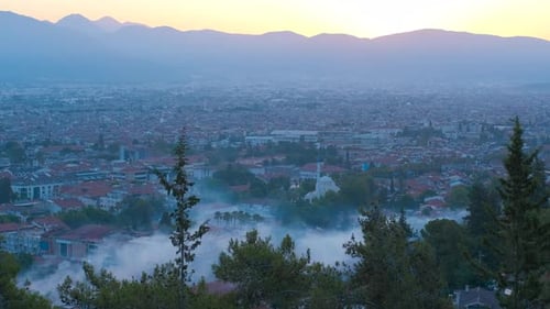 Fog Enveloping a Cityscape During the Enchanting Golden Hour