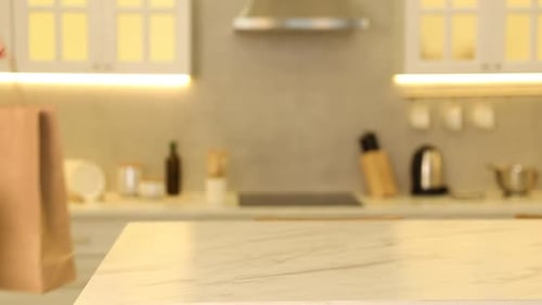 Envasado. Mujer poniendo bolsas de papel en la mesa en la cocina, primer plano
