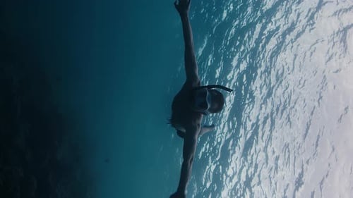 Plongée sous-marine. Jeune homme en forme plonge avec un masque dans la mer et nage sous l'eau
