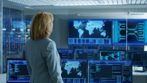 In the System Control Room Female Head of the Department Crosses Arms and Thinks Standing with Her