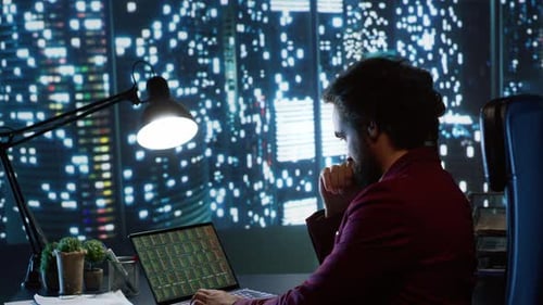 Man Analyzing Stock Data at Night in Office