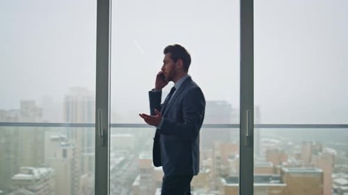 Man Professional Speaking Smartphone Negotiating at Panoramic Window Office