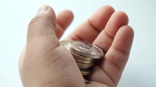 Stack of Gold and Silver Coins in Hand