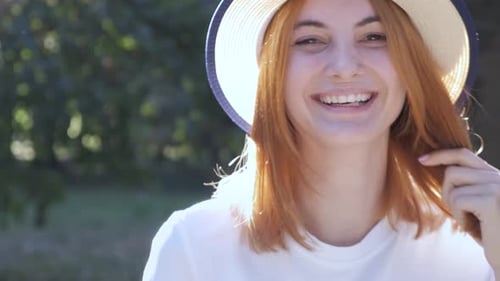 Pretty Teenage Girl with Red Hair Speaking on Mobile Phone Outdoors