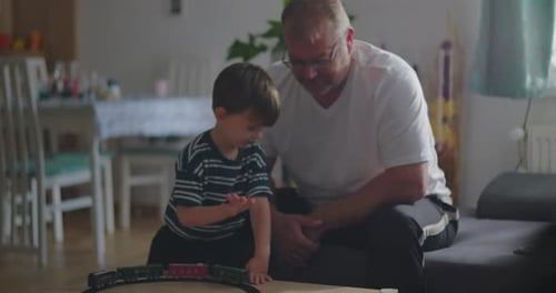 Father and Son Play with Toy Train at Home