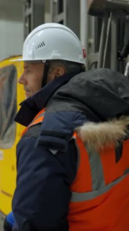 Vertical of Engineer Gets Out of Forklift Cabin After Testing Equipment
