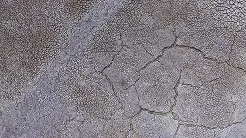 Dry and cracked gray soil ground during drought, viewed from above. top view. earthquake cracking ho
