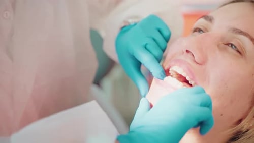 Dentist Adjusts Aligners in Young Woman's Mouth