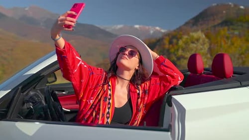 Schöne Frau filmt sich selbst mit dem Smartphone und macht Selfies auf Reisen in den Bergen