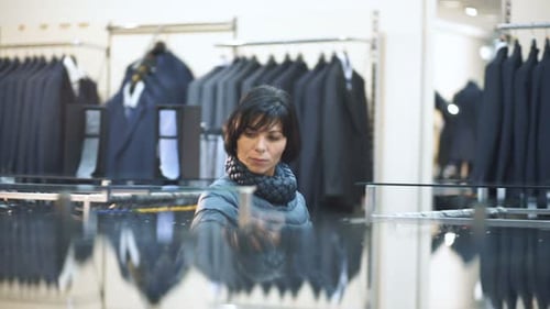 One Attractive Satisfied Seriouse Consumer Alone Looking Jackets in Mans Design Showroom