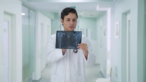 Dedicated Doctor Examining X-ray in Hospital Corridor