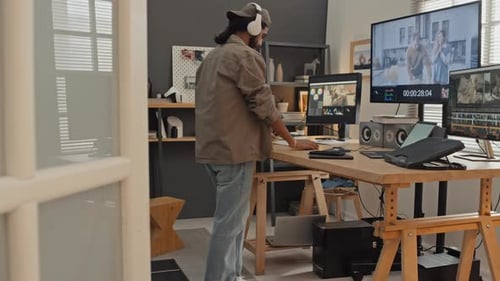 Freiberuflicher Grafikdesigner, der zu Hause in einer Bearbeitungssoftware an Filmmaterial arbeitet