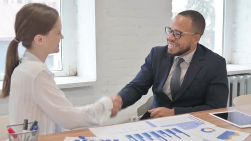 Business People Shake Hands in an Office