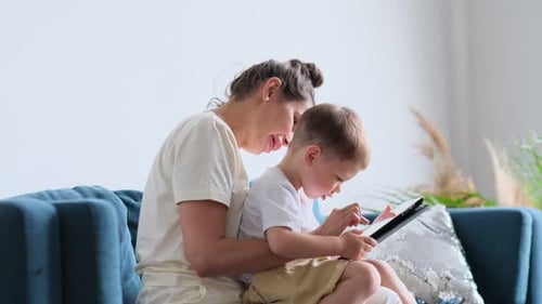 Mother and Child Using Tablet on Couch