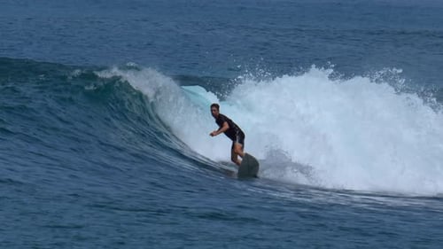 Surfer Rides Wave in Ocean During Daytime