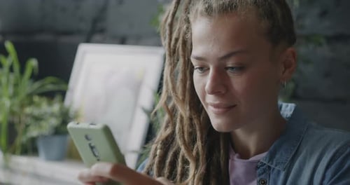Joyful Businesswoman Communicating with Smartphone Touching Screen and Smiling Indoors in Loft Style
