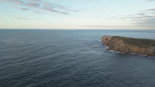 Aerial drone shot of the picturesque coastal island peninsula in Cantabria and the endless view of t