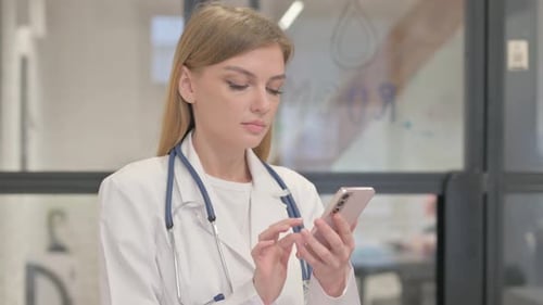 Female Doctor Using Mobile Phone in Modern Clinic