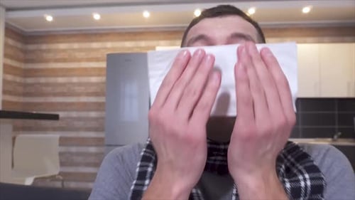 Adult Man Blowing Nose with a Tissue