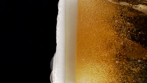 Superzeitlupenaufnahme von Bierblasen im Glas auf schwarzem Hintergrund mit 1000 Bildern pro Sekunde