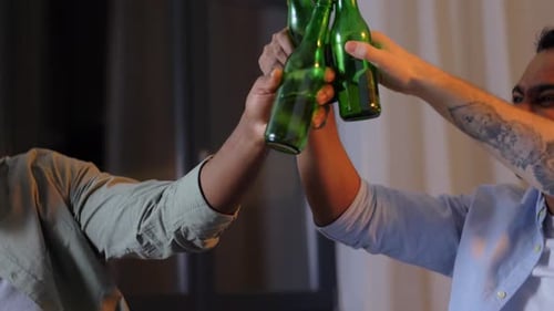 Three friends drinking beer and celebrating together indoors