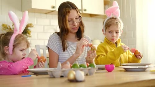 Kinder, Geschwister, die Osterei bemalen, zusammen am Tisch sitzen, Ostern, Familientraditionen, Jugendliches Mädchen