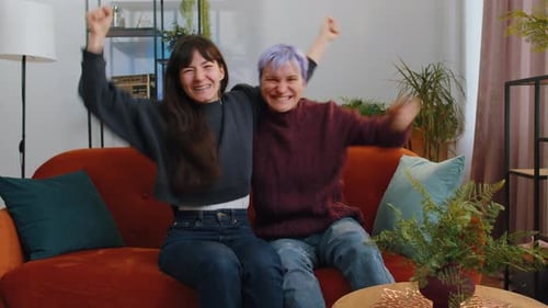 Two Young Women Celebrate Good News on Couch
