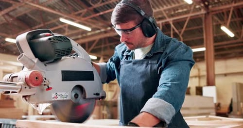 Carpenter, woodwork and man with electric saw in workshop for furniture production