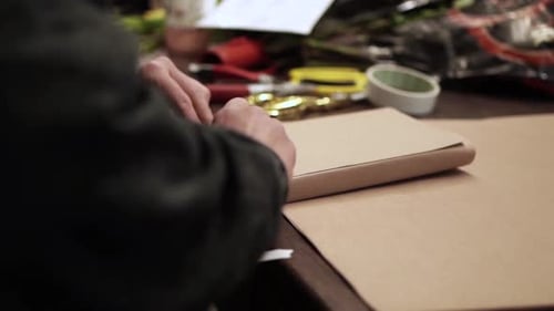 Wrapping a Present with Paper at a Table