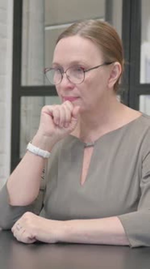 Pensive Senior Old Woman Sitting in Office, vertical video