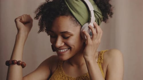 Close Up Portrait of Young Authentic Beautiful Stylish Black Woman Listening to Music Via Headphones