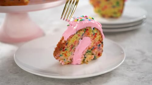 Funfettti-Bundt-Kuchen in Scheiben schneiden, mit rosafarbenem Buttercreme-Zuckerguss oben und Buttercremefüllung innen
