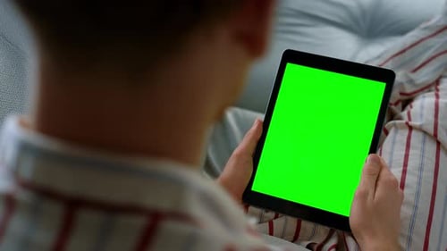 Man Holding Tablet Videocalling in Pajamas Closeup. Chroma Key Screen Device. Unrecognized