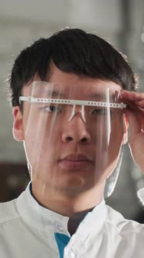 Engineer Adjusting Protective Glass in Automotive Workshop