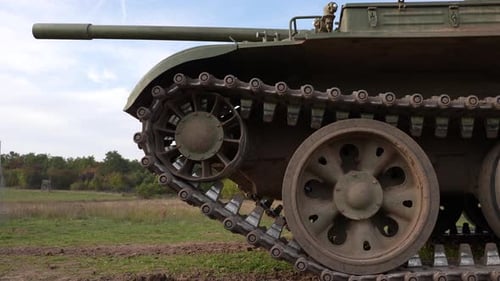 Military Tank Stationary in a Grassy Rural Field