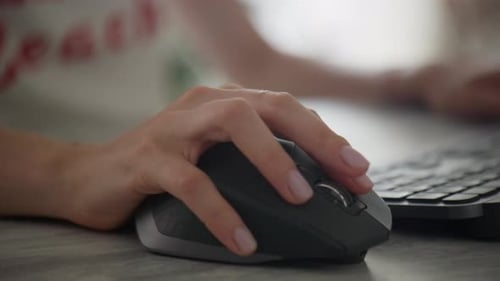 Woman's Hand Using Computer Mouse on Desk