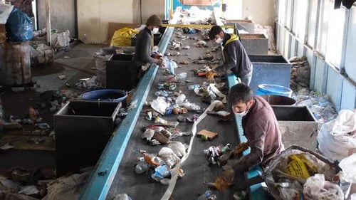 Cleaning Workers Sorting Garbage At Recycling Plant