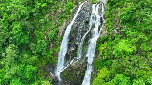 Beautiful waterfall in the green tropical forest. Drone aerial view.