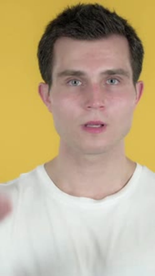 Man Gesturing No on Yellow Background in Studio