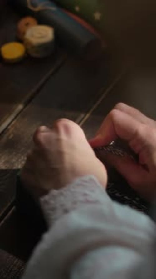 Vertical Video Hands Wrap Christmas Present in Wrapping Paper and Tie a Bow