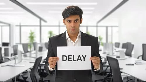 Man Holds Delay Sign in Bright Modern Office