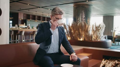 Middleaged Caucasian Businessman Sitting at Table in Cafe Looking at Watch Handsome Grayhaired Man