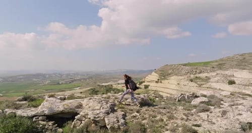 Aerial View of a Woman with a Backpack Climbing the Rocks in the Mountains